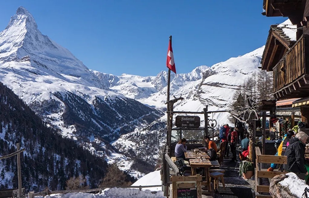 terasa restaurantului findelhorf, iar in departare muntii cu zapada, in Zermatt Elveția