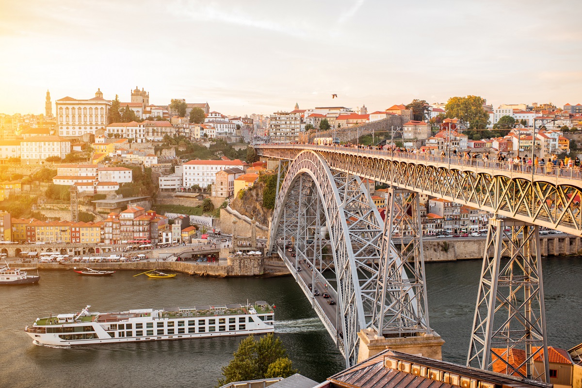 Panoramic landscape view on the old town with Douro river and famous iron bridge in Porto city during the sunset in Portugal
