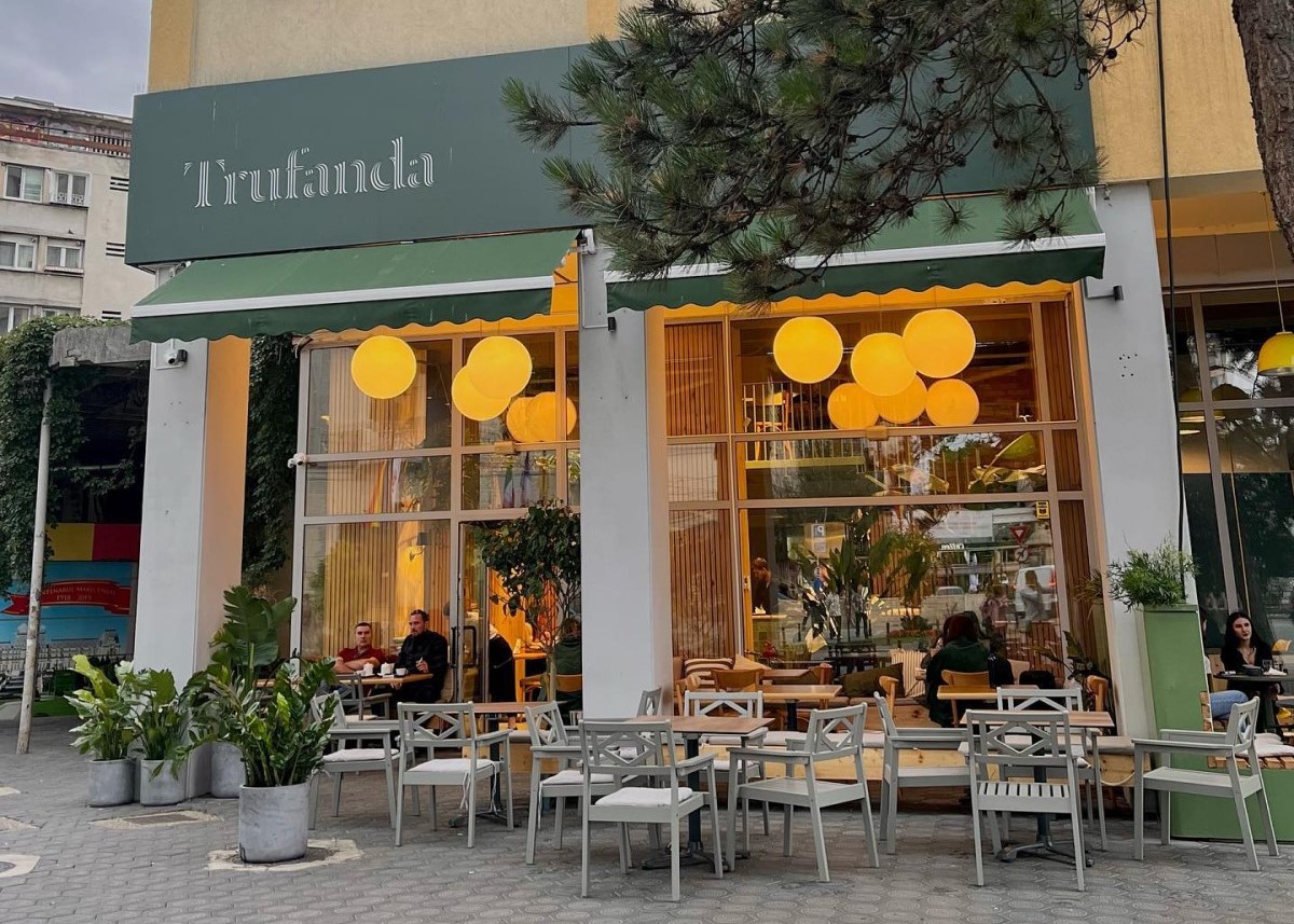 terasa de la restaurant Trufanda, cu mese asezate pe trotuar in fata geamurilor inalte prin care se vad candelabre rotunde aprinse, unul din restaurante bune din Iași