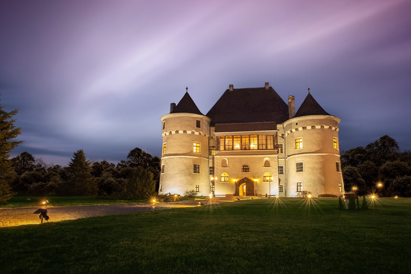 Castelul Bethlen-Haller fotografiat din departare, la lasarea serii, cu luminile aprinse - una din destinații romantice din România