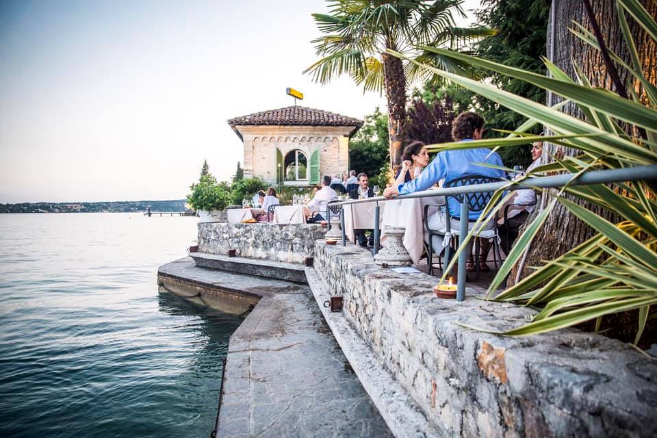 terasa restaurantului Lido 84 din Italia, cu mese asezate pe terasa pe malul lacului Garda